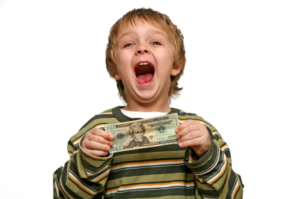 Boy with a big smile holding a $20 bill.