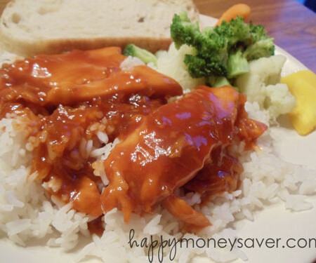 Sweet and sour chicken on a plate with rice and vegetables.