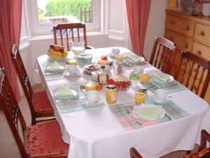 Table set with plates, glasses, and food.