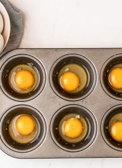how to freeze eggs - 6 cracked eggs in a muffin tin, one egg per slot plus a bowl of eggs nearby