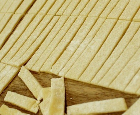 Dough sliced into long rectangles.