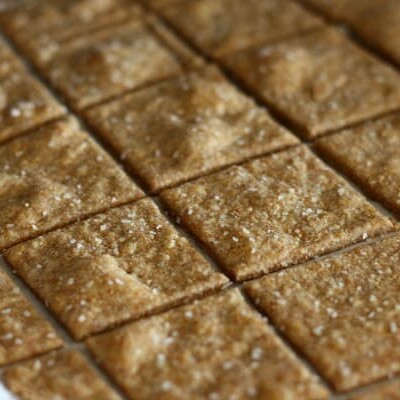 Homemade wheat thin crackers on parchment paper.