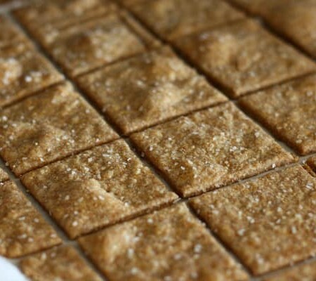 Homemade wheat thin crackers on parchment paper.