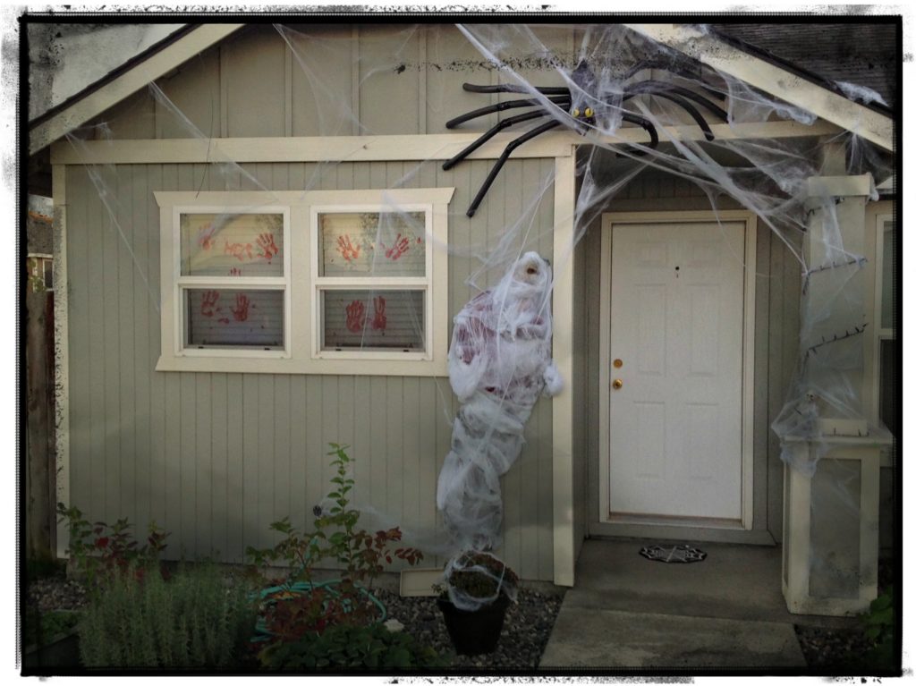 Thrifty & Super spooky halloween porch decorating idea using a spider and fake man. Creepy!