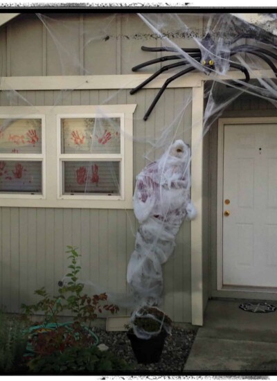 Thrifty & Super spooky halloween porch decorating idea using a spider and fake man. Creepy!