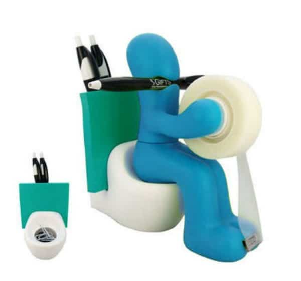 A Claymation person sitting on a toilet holding office supplies like tape and pens.