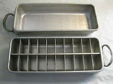 Two rectangular metal trays, one of which is divided into smaller rectangles.