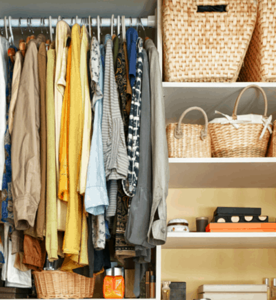 Closet full of clothes, shelves, and wicker baskets.