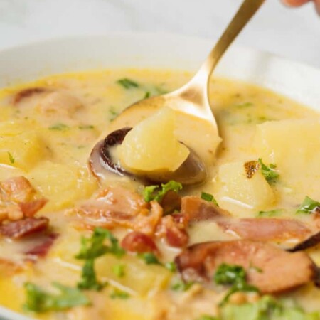Spoon scooping Zuppa Toscana soup from a bowl.