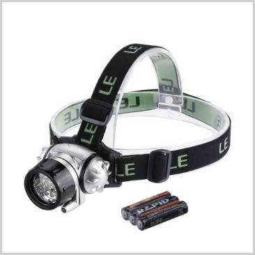 A headlamp with batteries on the side on a list of 18 cool camping equipment ideas.