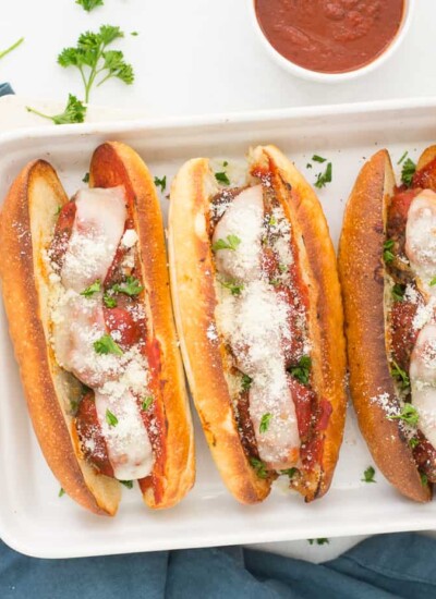 Three meatloaf subs on a white dish.