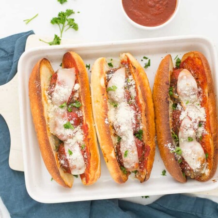 Three meatloaf subs on a white dish.