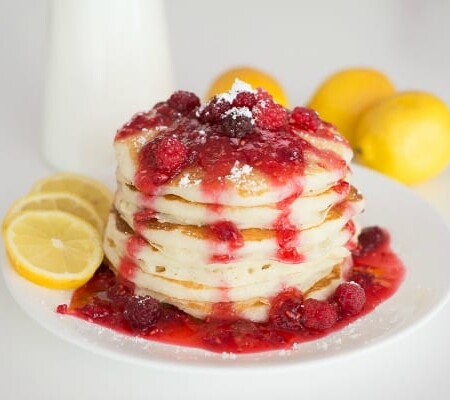 Stack of lemon pancakes topped with fruit.