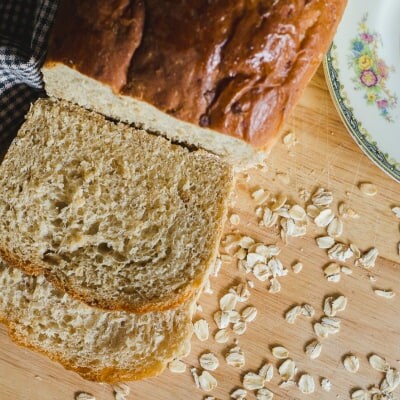 Partially-sliced loaf of country oatmeal bread.