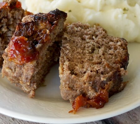 Slices of mini meatloaf on a plate with mashed potatoes.