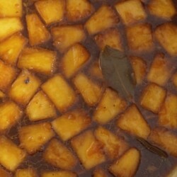 Pineapple bits and sauce in a pot.
