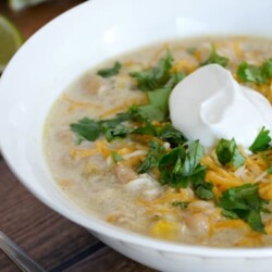 Bowl of white chicken chili topped with sour cream.