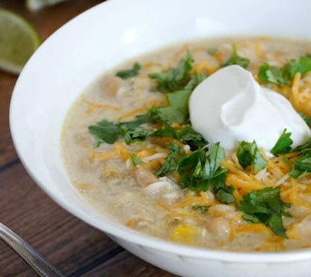 Bowl of white chicken chili topped with sour cream.