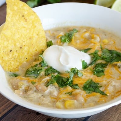 Tortilla chip in a bowl of white chicken chili.