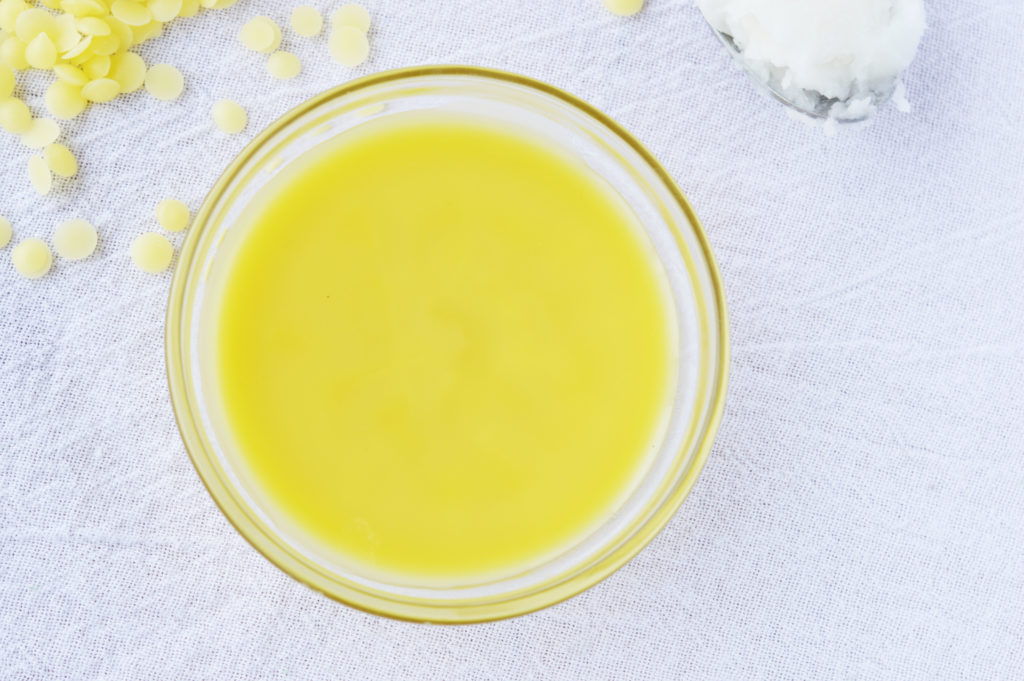 Bright yellow allergy relief balm in a glass jar.