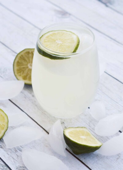 Glass of sparkling ginger limeade topped with a lime slice.