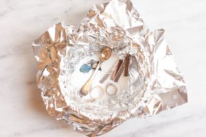 Jewelry in an aluminum-foil-lined bowl with homemade jewelry cleaner.