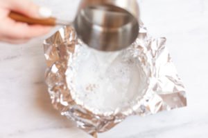 Water pouring into an aluminum-foil-lined bowl.