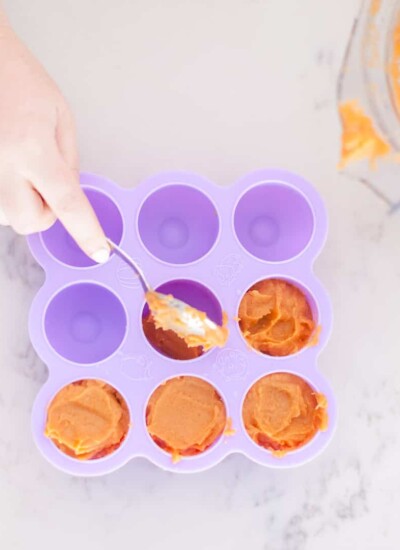 Person filling a freezer tray with baby food.