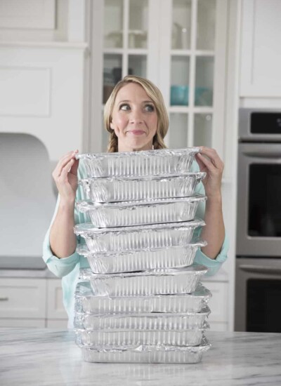 Karrie smiling behind a tall pile of disposable baking pans.