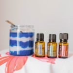 Bottles of doTerra essential oils with a jar of blue and white sugar scrub.