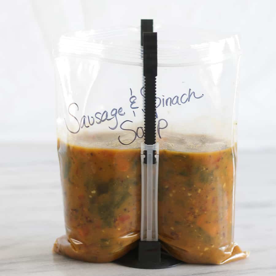 Freezer bag of sausage and spinach soup in a bag holder.