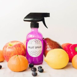 Fruit surrounding a purple spray bottle labeled "Fruit Spray."