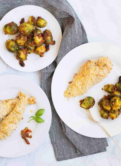 Plates of cheesy crunch chicken and Italian brussels sprouts.