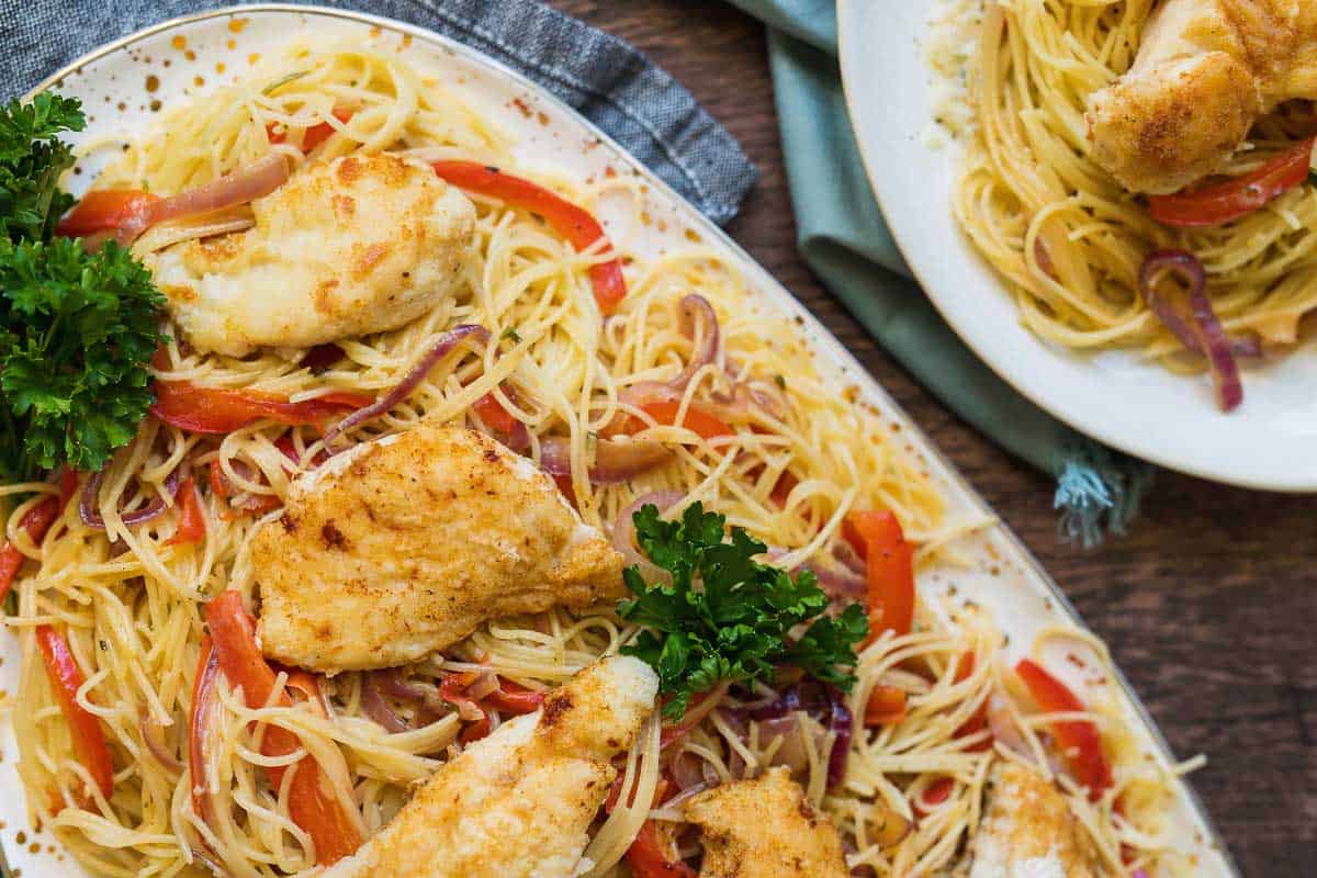 This chicken scampi recipe is to die for. Angel hair pasta covered in a creamy garlic sauce with caramelized onions and bell peppers & topped with chicken. 