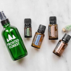 Bottles of doTerra essential oils next to a spray bottle labelled "Frosted Forest."