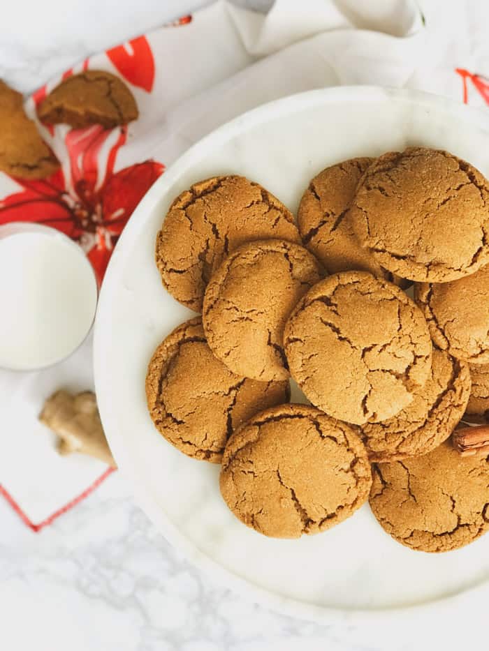 soft delicious chewy ginger molasses cookies on a plate with a glass of milk
