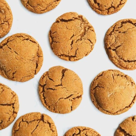 Chewy ginger molasses cookies on a white surface.