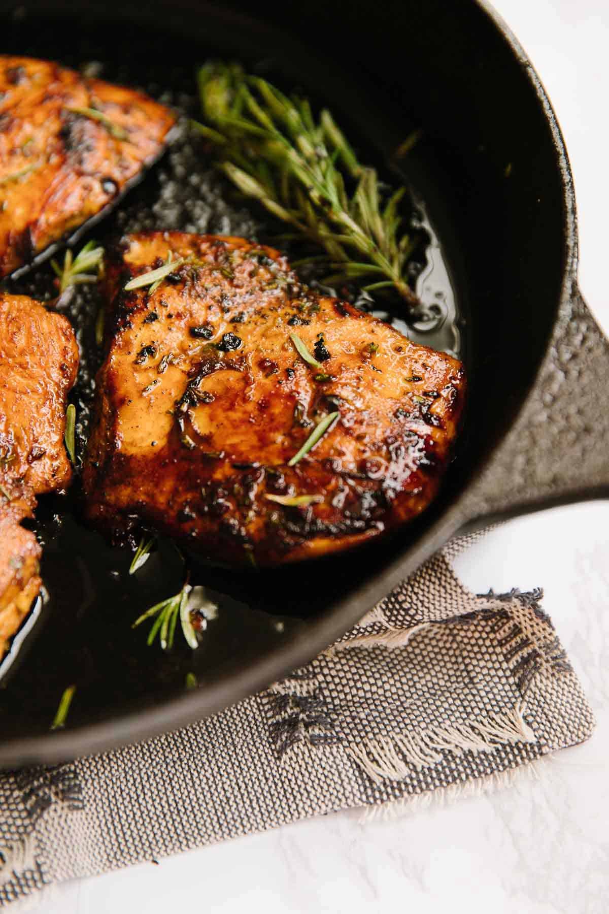 Balsamic Rosemary Chicken cooked in a skillet with fresh rosemary sprigs.