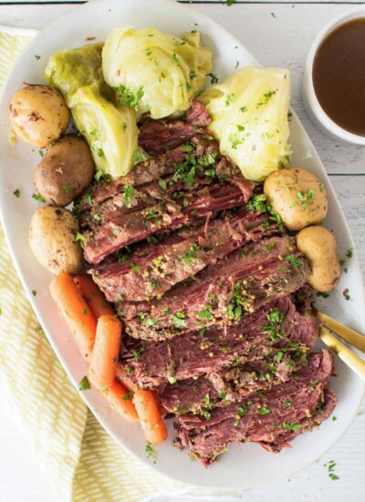 Serving platter of corned beef and cabbage with vegetables.