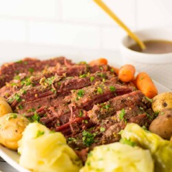 Serving platter of corned beef and cabbage with vegetables.