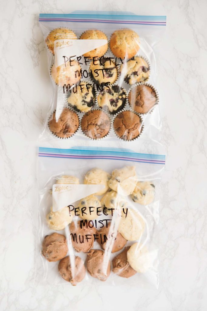 One gallon size ziploc bag with poppyseed, blueberry, and chocolate cooked muffins in it. Another gallon size ziploc bag has uncooked muffin batter in it. The words "Perfectly Moist Muffins" are written on both bags.