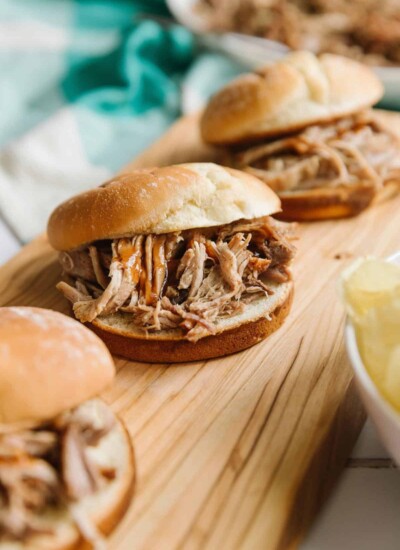 Pulled pork sliders on a wooden board.