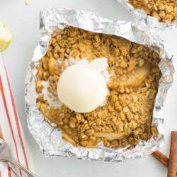 Apple crisp foil packet topped with a scoop of ice cream.