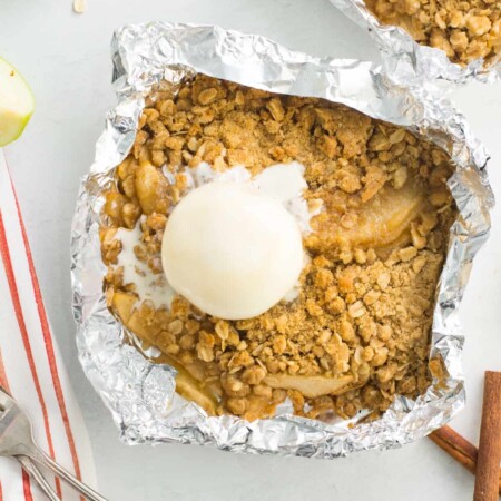 Apple crisp foil packet topped with a scoop of ice cream.