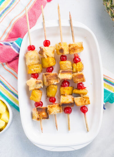 White dish of pineapple upside down cake kabobs.