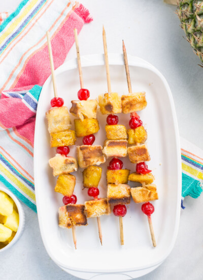 White dish of pineapple upside down cake kabobs.