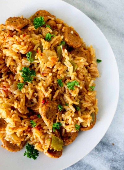 White plate of Cajun chicken sausage and rice.