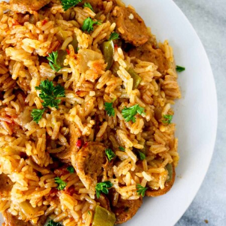 White plate of Cajun chicken sausage and rice.