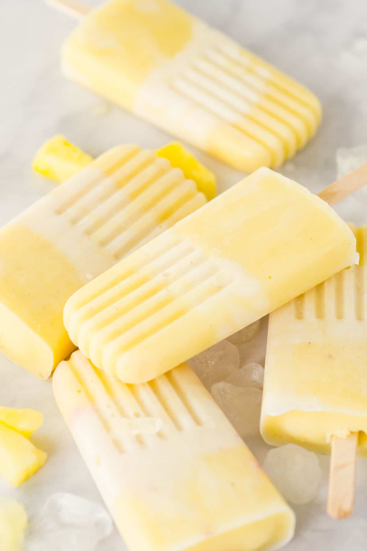 Yellow and white popsicles that are homemade using pineapple and cream. 