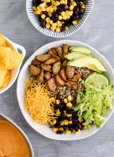 Quinoa burrito bowl with cheese, avocado, lettuce, and more.